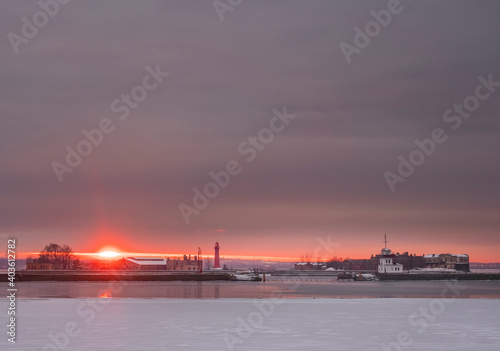 Winter sunset in the port city of Kronstadt St. Petersburg. with a view of the fort Kronslot island and the lighthouse.