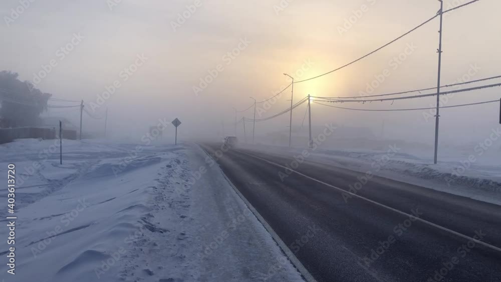 winter -50 degrees, very cold city. white car is passing. foggy road. republic of sakha yakutia in january winter -50 degrees, very cold city. white car is passing. foggy road. republic of sakha yakutia in january