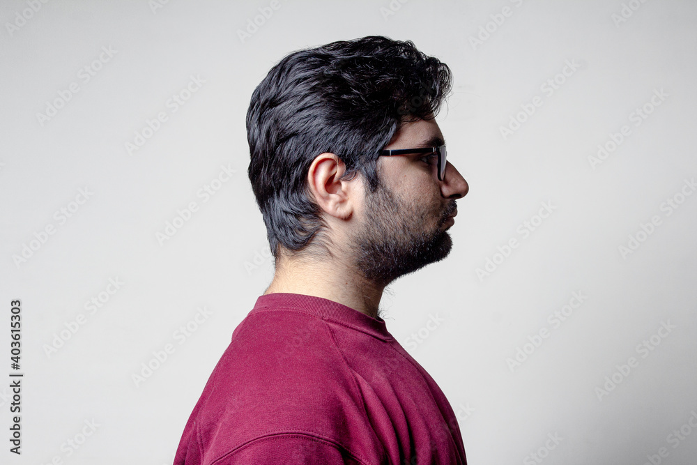 A man standing towards wall with a side pose A man standing towards wall with a side pose