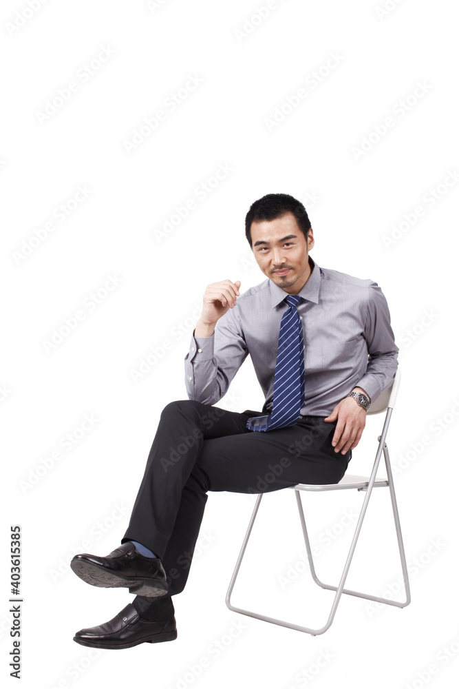 A cheerful young business man sitting posture A cheerful young business man sitting posture