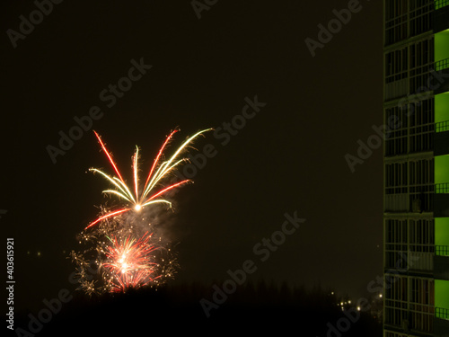 New Year or Christmas fireworks in the Russian suburbs. Composite photo of a color salute in the courtyard of a sleeping area of the city.