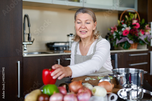 Senior woman in kitchen preparing food.