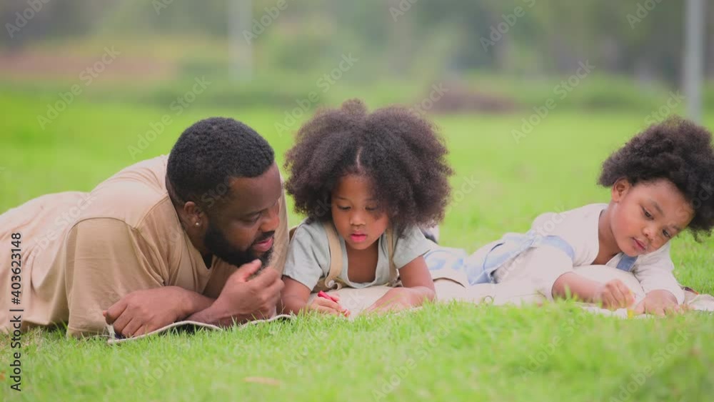 Happy african family is enjoying and picnic in the park. Father, son and daughter resting by writing and drawing on outdoor in garden. Happy family day vacation concept. Happy african family is enjoying and picnic in the park. Father, son and daughter resting by writing and drawing on outdoor in garden. Happy family day vacation concept.