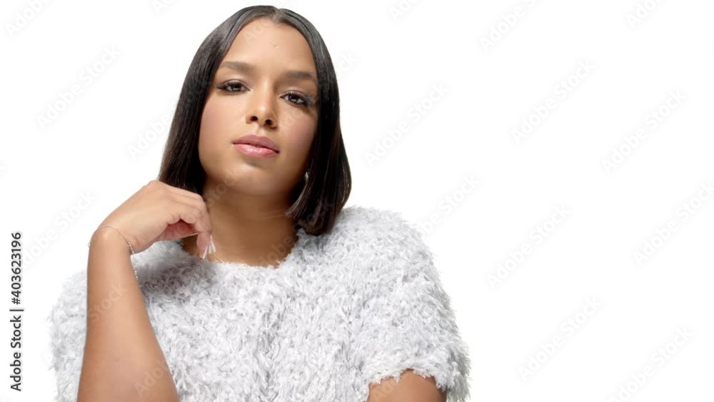 Mixed race black beautiful young woman with dark straight hair on a white plain background posing, looking in the camera and touching her chin with the hand. Portrait medium close-up tracking 4k video Mixed race black beautiful young woman with dark straight hair on a white plain background posing, looking in the camera and touching her chin with the hand. Portrait medium close-up tracking 4k video