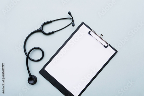 Принти на полотні Black stethoscope and blank medical form on grey background