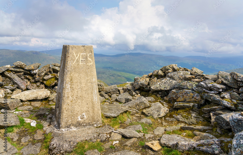 The word yes scratched onto the summit cairn of Meall Ghaordaidh near Loch Tay in the Scottish Highlands, UK.