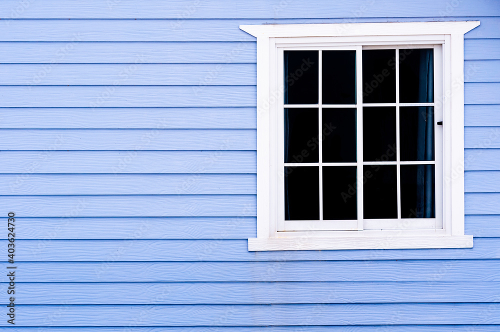 White frame vintage window on blue wooden wall.
