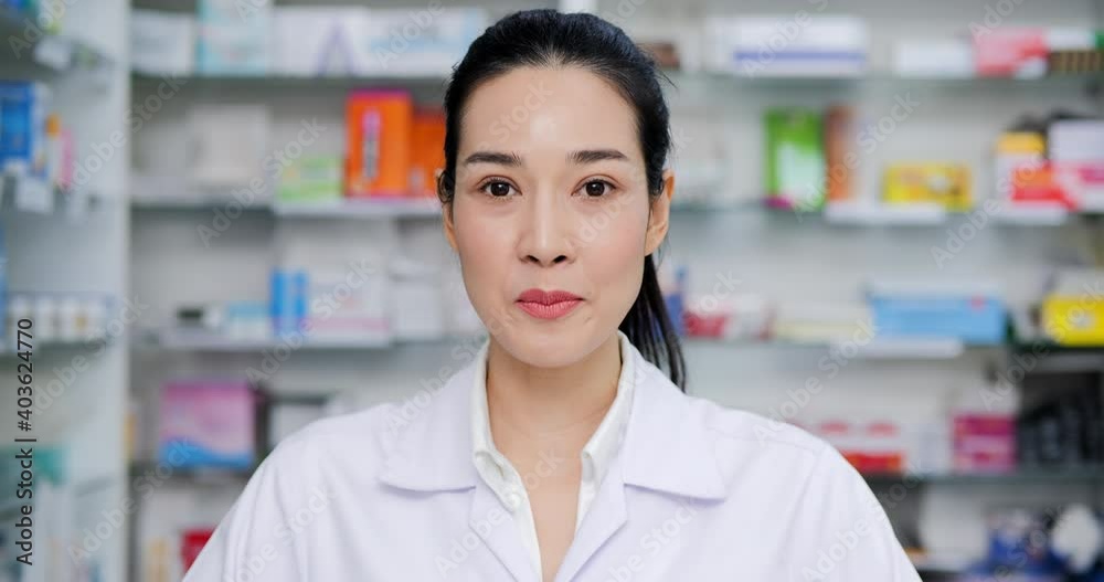 Portrait of female doctor talking to camera at drugstore. Female doctor explaining drug information to patients. Portrait of female doctor talking to camera at drugstore. Female doctor explaining drug information to patients.