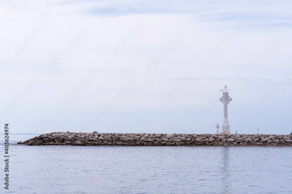 White local lighthouse on breakwaters line coastal protection