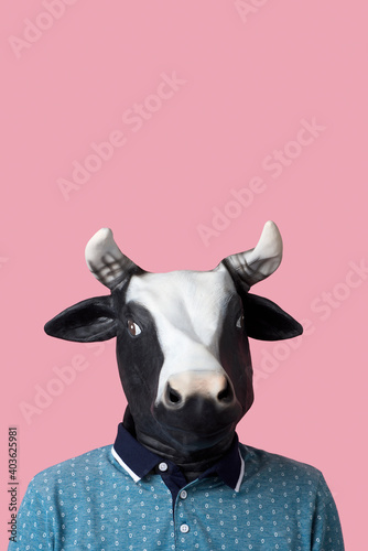 man wearing a cow mask on a pink background © nito