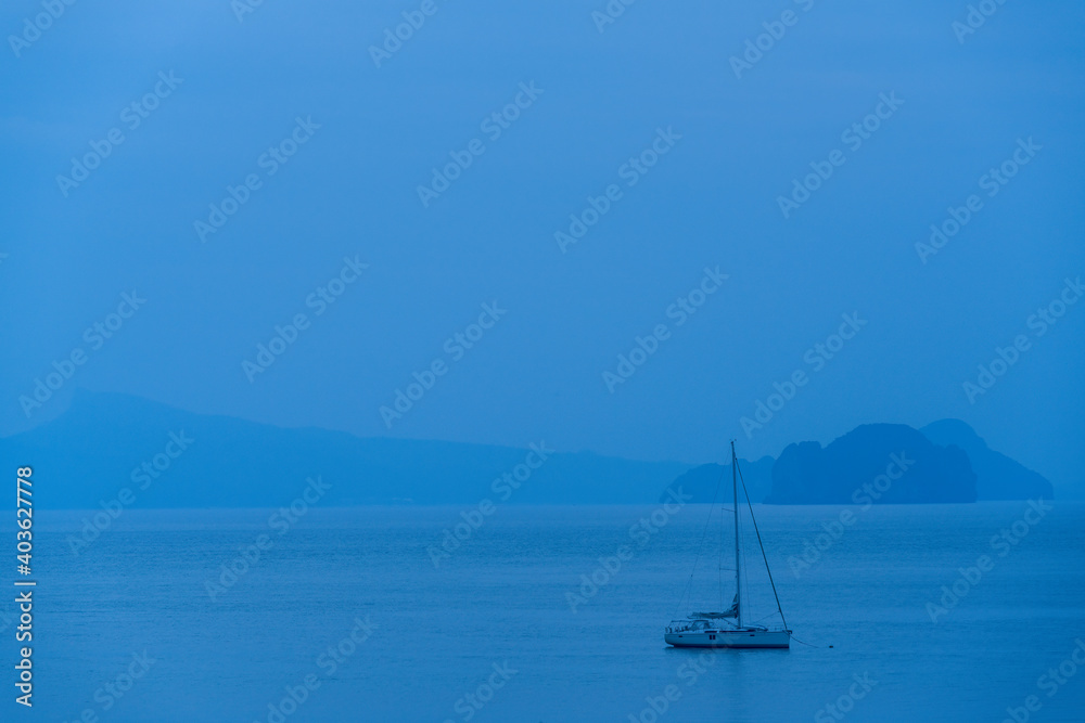 Anchored yacht in the Andaman Sea off the coast of Khao Yao, Phang Nga, Thailand at blue hour.