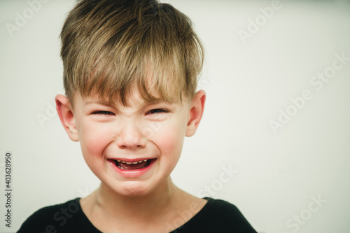 portrait of a crying offended boy on a light background