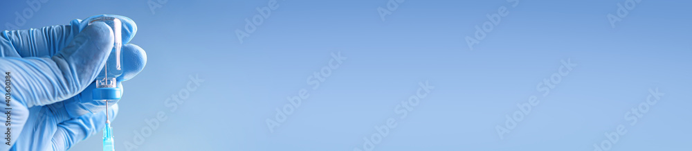Φωτογραφία Doctor in blue latex gloves fill in syringe with medicine from glass vial