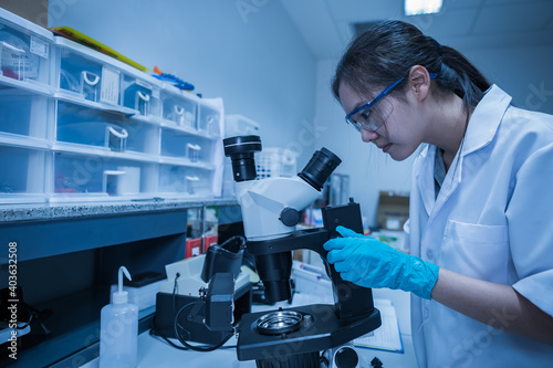 Asian scientist working in the lab,Researchers are research to find the results of the experiment,doctors are testing bloods to prevent and destroy new strains of the coronavirus through microscopy