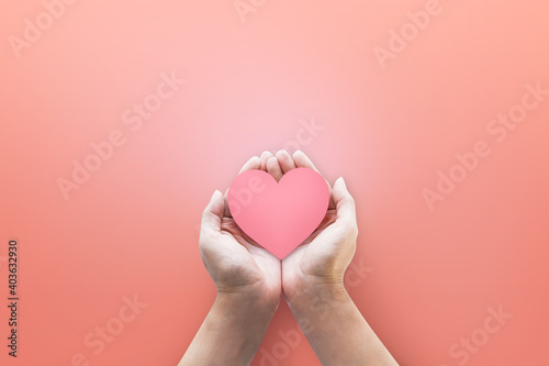 Hand holding heart icon at pink background. for love.