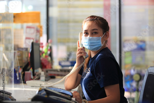 Young woman with face mask back at work in office after lockdown