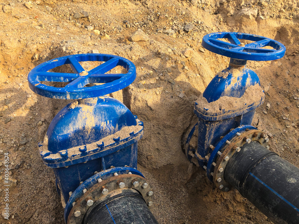 Valves on pipeline in ground. Pipe valves in trench