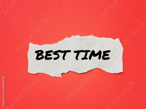 Text BEST TIME on brown torn paper isolated on red background.Inspirational quote.