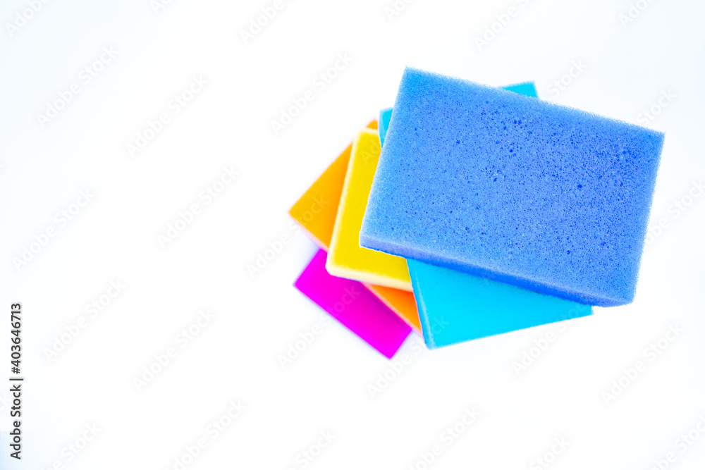 Top view of sponges for washing dishes, on a white background, isolated. Colorful multi-colored as rainbow sponges lay one each other Top view of sponges for washing dishes, on a white background, isolated. Colorful multi-colored as rainbow sponges lay one each other