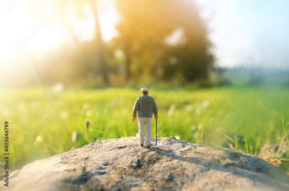 Obraz premium Surreal image of mysterious man walking alone in field during sunset