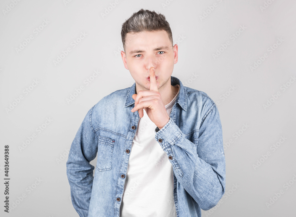 Young handsome man over gray background asking to be quiet with finger on lips. Silence and secret concept. Young handsome man over gray background asking to be quiet with finger on lips. Silence and secret concept.