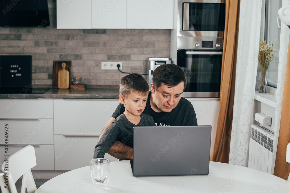 Father working from home with children at kitchen table Father working from home with children at kitchen table