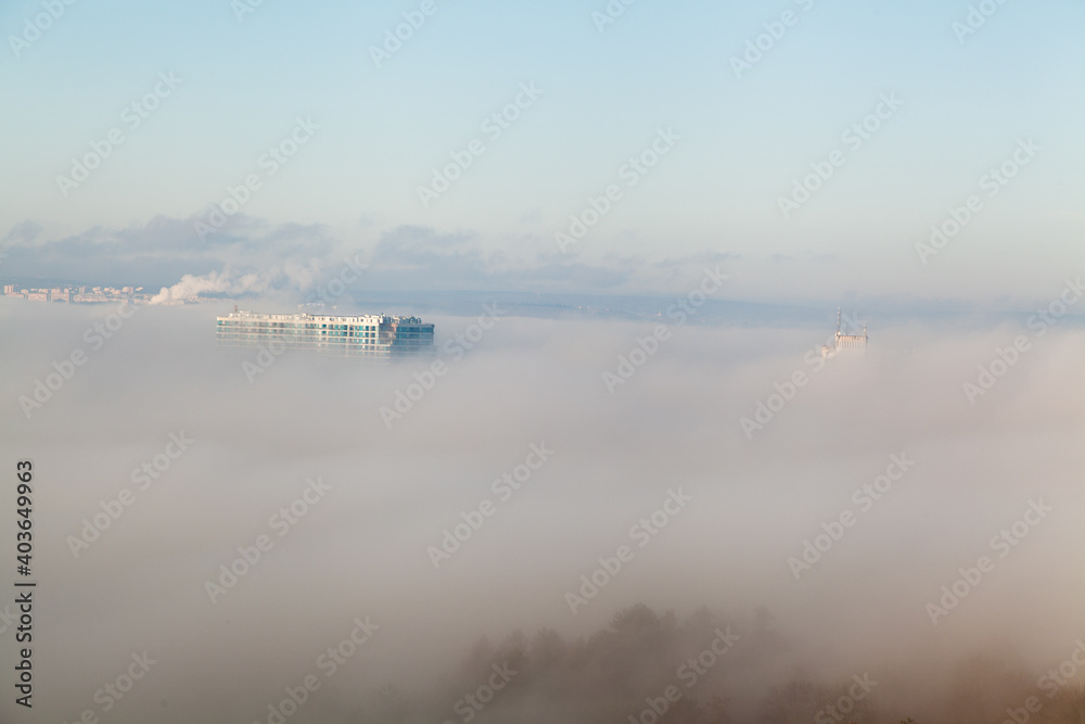 Roof of a building in the fog with blue sky