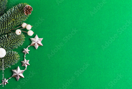 Green background with Christmas tree, pine cone, stars and beads.