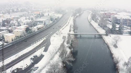 Flying over a river in a snow blizzard. on the left side is the highway with cars on it. photo