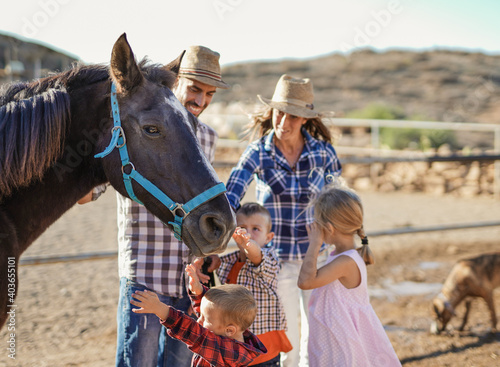 Happy family cuddle horse outdoor ar ranch - Human and animal love
