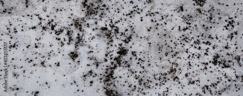 Badly stained texture on the snowy road 