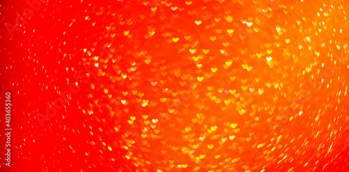 Blurred out of focus bokeh background. Texture from red orange hearts. Preparation for a holiday greeting card. Abstract valentines day, festive love. Place for text, copy space. Banner sunset of sun