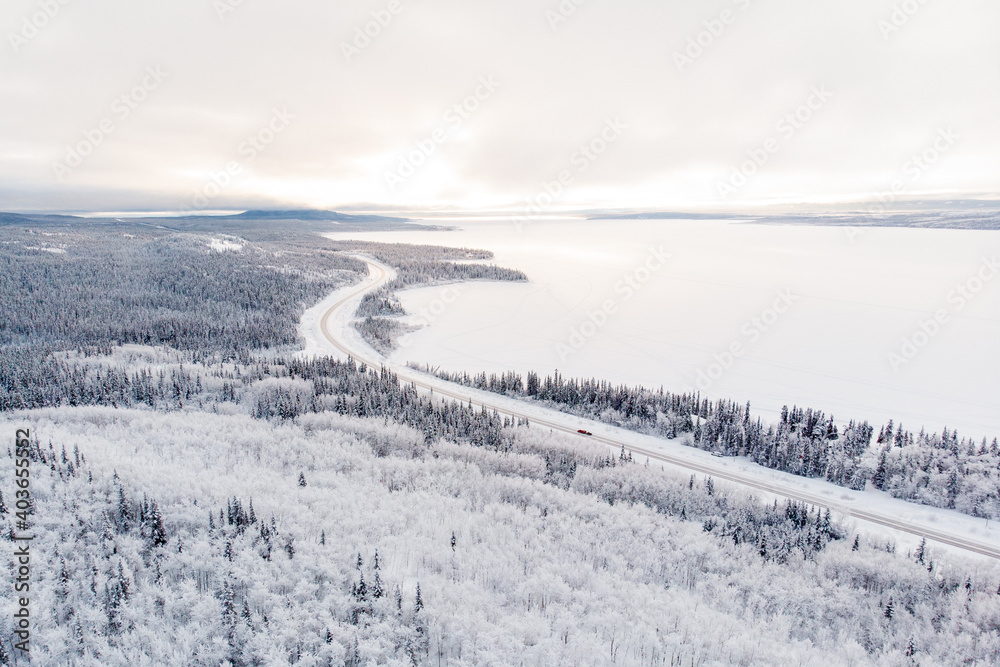 Stunning winter aerial view, drone of Yukon Territory in northern Canada. Taken in December cold, freezing season with wilderness woods and huge frozen lake. Stunning winter aerial view, drone of Yukon Territory in northern Canada. Taken in December cold, freezing season with wilderness woods and huge frozen lake.