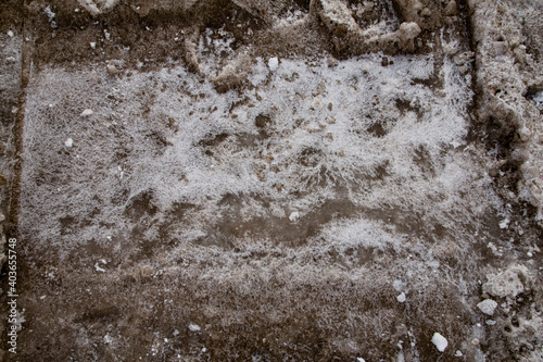Badly stained texture on the snowy road 