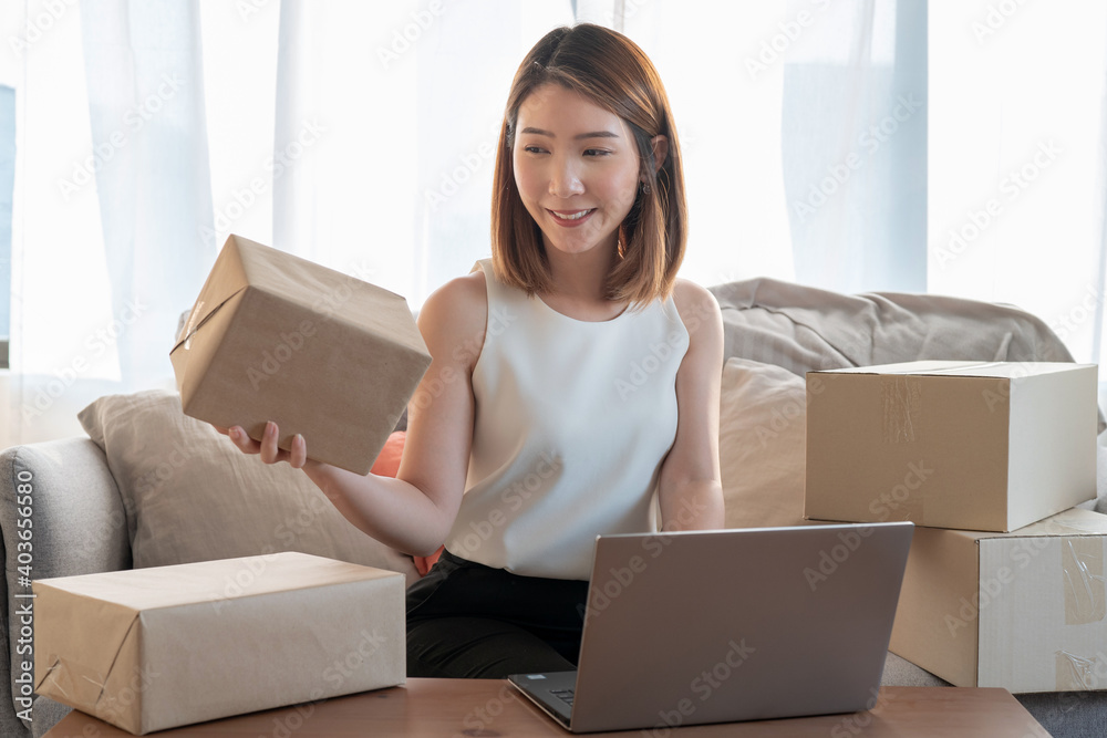 The small business owner smiles and writes information on the parcel, Online trading ideas and product delivery. The small business owner smiles and writes information on the parcel, Online trading ideas and product delivery.