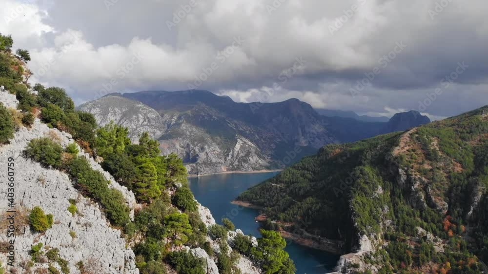 Aerial view of a water dam, reservoir lake and mountains covered with greenery, trees. Concept of crystal clear water, rest, travel, no people, heaven on earth Aerial view of a water dam, reservoir lake and mountains covered with greenery, trees. Concept of crystal clear water, rest, travel, no people, heaven on earth