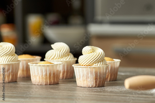 Closeup of classic cupcakes with cheese cream in paper cups