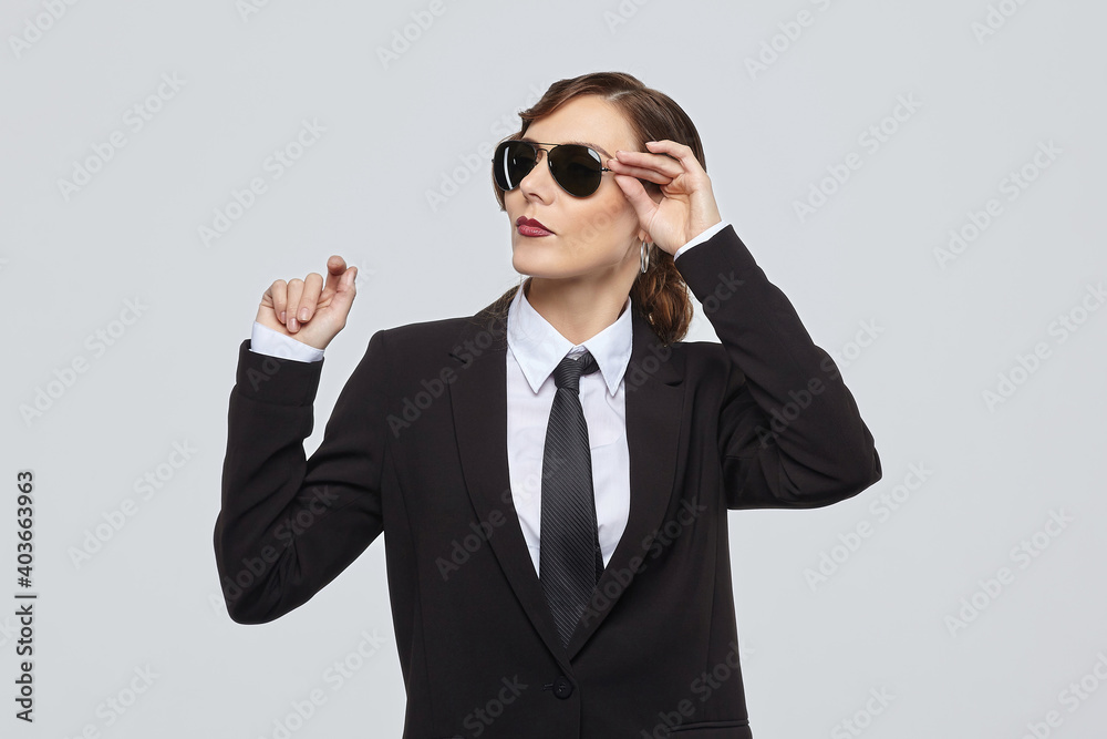 attractive woman with a retro hairstyle poses in a men's suit and sunglasses attractive woman with a retro hairstyle poses in a men's suit and sunglasses