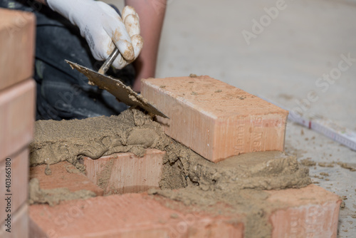 Bricklayer Builds Bricks Wall - Closeup Craftsman photo