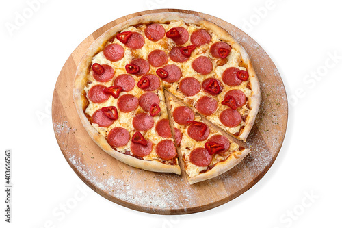 Whole Spicy Italian Pepperoni Pizza with salami slices, fresh chilli pepper and mozzarella cheese served on wooden plate served with culinary flour and spices, isolated on white background
