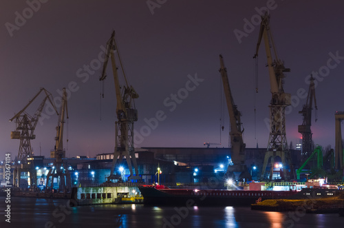 SHIPYARD - Cranes, wharves and industrial buildings in night illumination