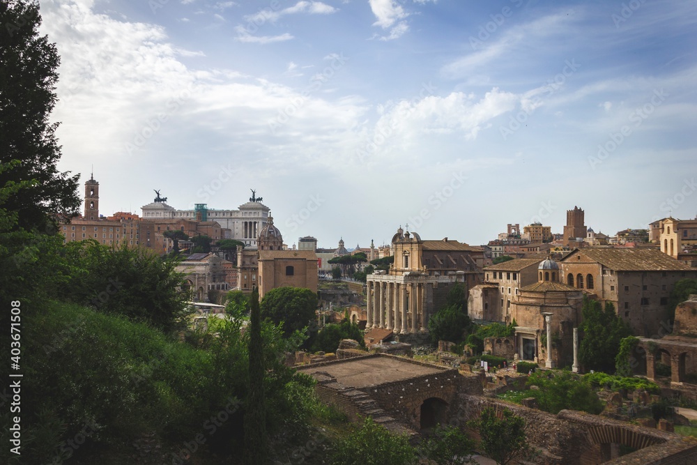 A landscape shot of the ancient part of the city of Rome in Italy. The view is of a part of the forum romanum with all the typical traditional roman architectural styles embedded into the buildings.