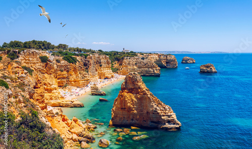 Praia da Marinha, beautiful beach Marinha in Algarve, Portugal. Navy Beach (Praia da Marinha) with flying seagulls over the beach, located on the Atlantic coast in Lagoa Municipality, Algarve.