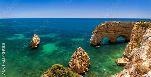 Natural caves at Marinha beach, Algarve Portugal. Rock cliff arches on Marinha beach and turquoise sea water on coast of Portugal in Algarve region.