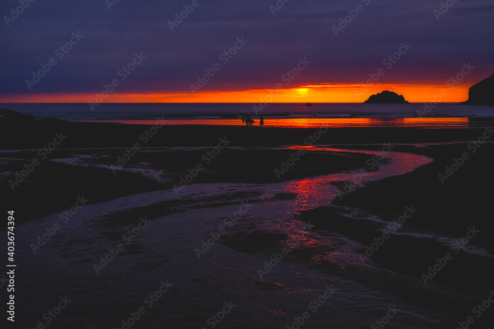 A dramatic sunset at the end of the day on the main beach at Polzeath, Cornwall A dramatic sunset at the end of the day on the main beach at Polzeath, Cornwall
