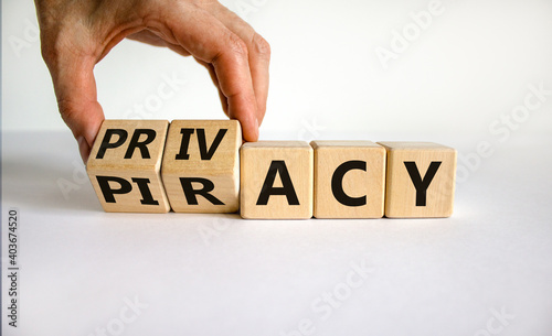 Privacy vs piracy symbol. Businessman hand turns cubes and changes the word 'piracy' to 'privacy'. Beautiful white background, copy space. Business and privacy vs piracy concept.