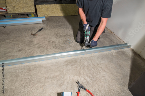 Close up view of male worker with electric hammer drill. Construction concept.