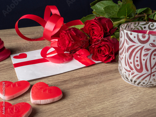 Fototapeta Naklejka Na Ścianę i Meble -  Red roses with candles, red hearts and white card with ribbon