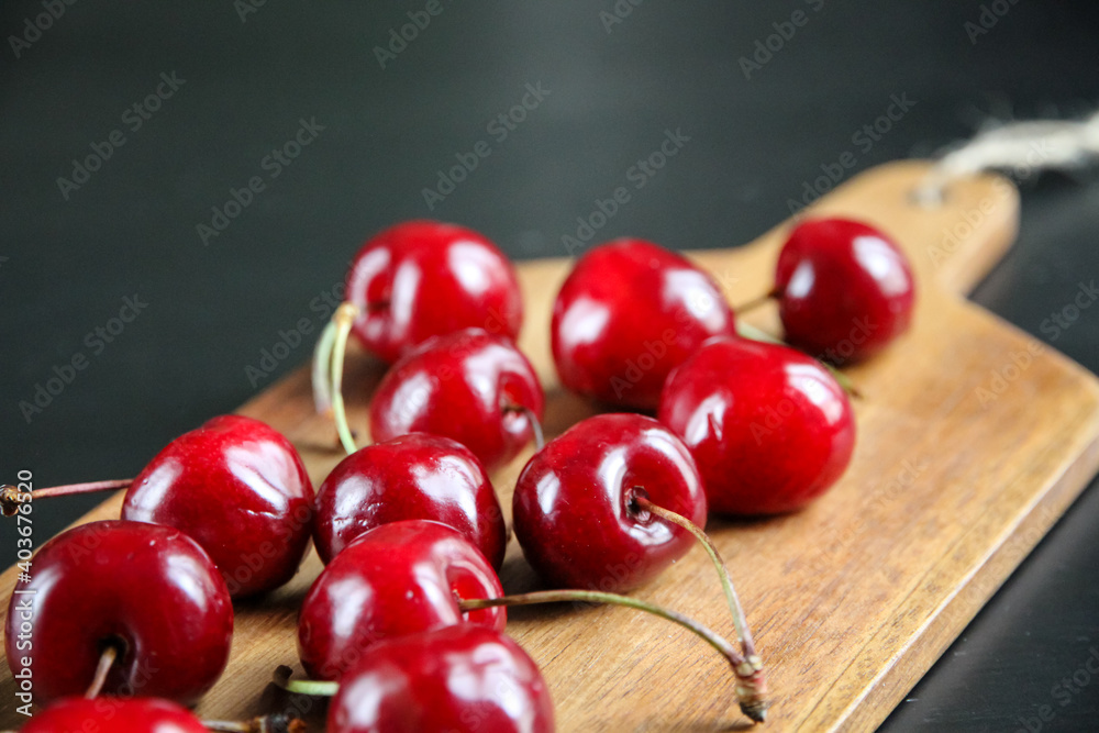 Fresh cherries on a wooden cutting board