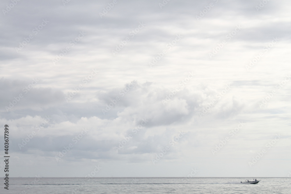 speedboat crosses the sea in a minimalist caribbean scene, cloudscape and navy blue speedboat crosses the sea in a minimalist caribbean scene, cloudscape and navy blue